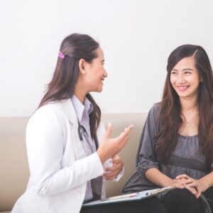A female doctor is with a female patient.
