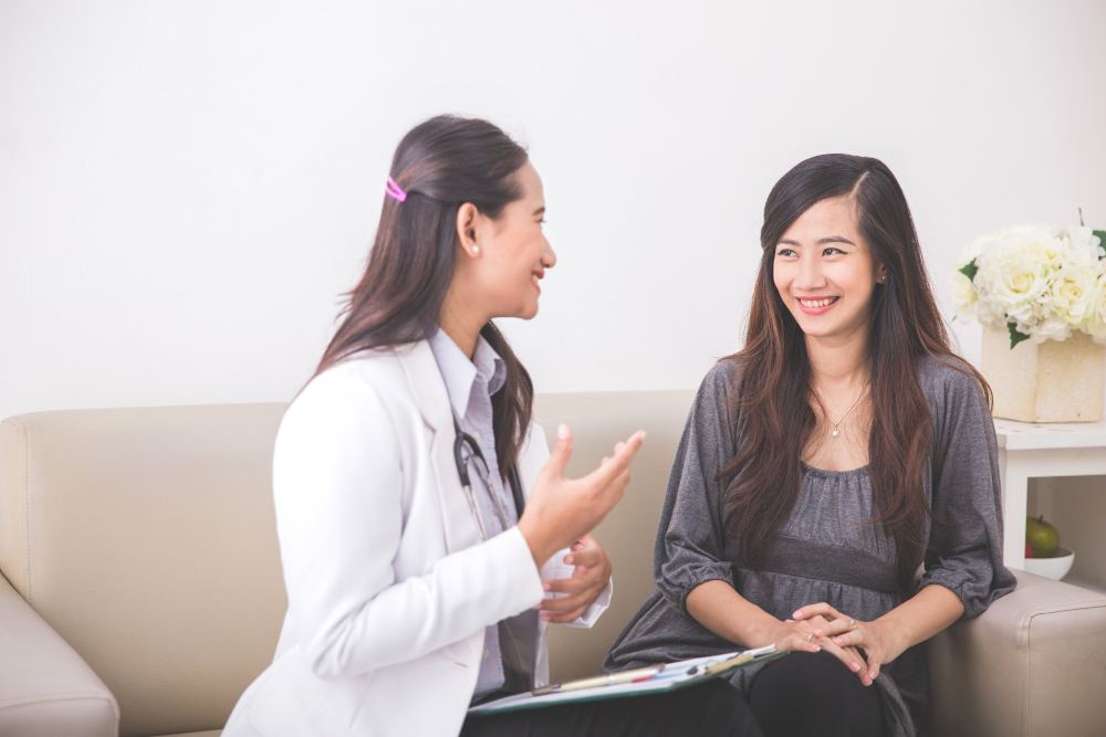 A female doctor is with a female patient.